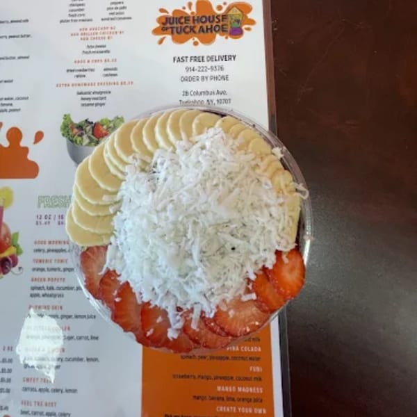 Juice House of Tuckahoe acai bowl with bananas, shredded coconut, and strawberries on a menu.